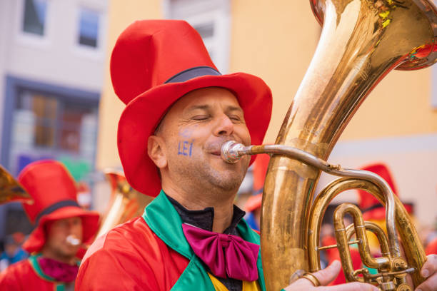 os participantes do tradicional desfile do festival na áustria usam roupas coloridas e mascaradas enquanto se movem pelas ruas de villach durante o evento anual fasching - parade tulip - fotografias e filmes do acervo