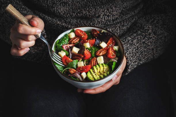 istock Healthy homemade salad with tomatoes, cheese cubes, pecans, avocado, spinach and arugula. 1467714321