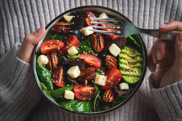 istock Healthy homemade salad with tomatoes, cheese cubes, pecans, avocado, spinach and arugula. 1467714329