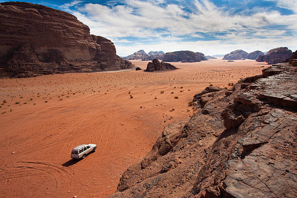 White jeep between the mountains in Wadi Rum, Jordan. stock photo