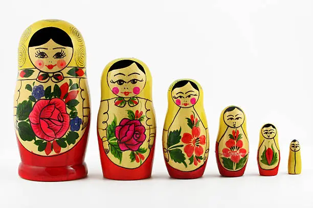 Russian nesting dolls ( babushkas or matryoshkas ) isolated on white background.