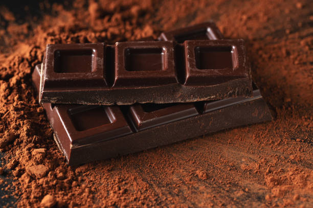 istock Dark and milk chocolate with nuts on a dark background sprinkled with cocoa powder. 1467718448