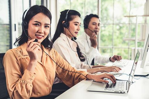 Business people wearing headset working actively in office . Call center, telemarketing, customer support agent provide service on telephone video conference call.