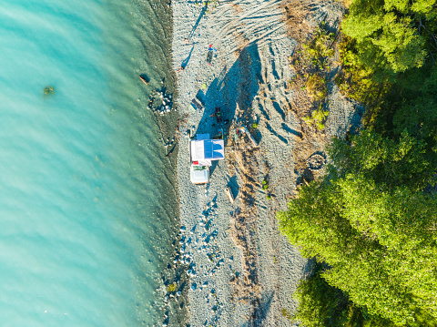 Drone aerial view of  a camper van standing near a river , the concept of vacation travel.