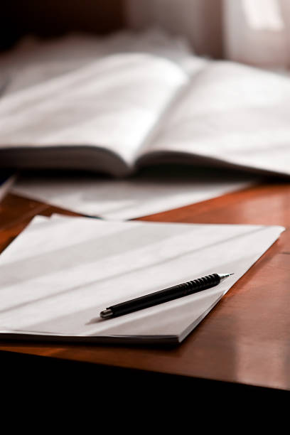 istock Open book and pen on white paper. 146771992
