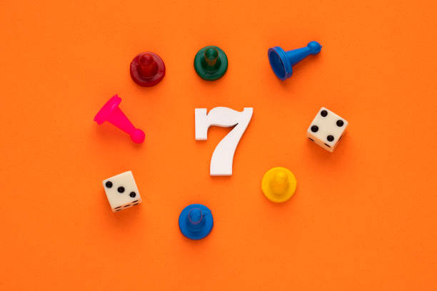 istock Number 7 with dice and board game pieces - Orange eva rubber background 1467728481