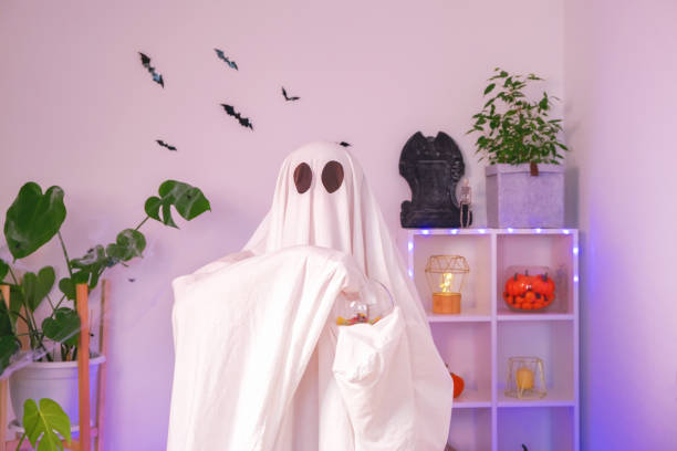 istock ghost eats Halloween sweets. A ghost eats worms, candy, sweets or muck, purse or life. Merry Halloween. 1467731527