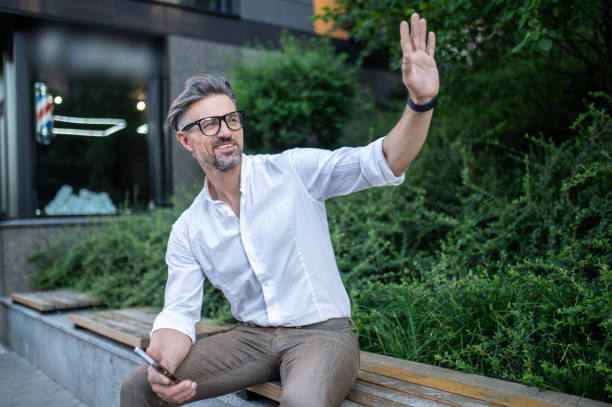 istock A man looking aside and waving his hand while meeting somebody 1467732454