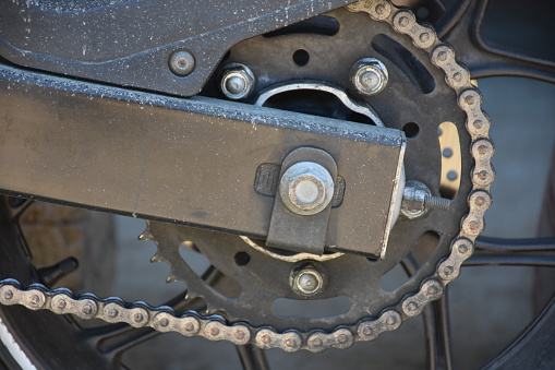 Close up of motorcycle gear chain system and wheels.