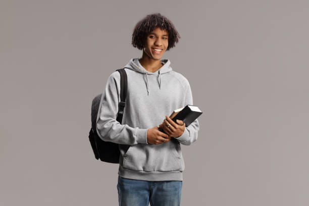 istock African american male student with a backpack holding books and smiling 1467743805