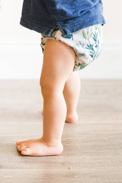 istock A 1-Year-Old Baby Boy Playing on the Floor & Learning to Walk While Wearing Just a Cloth Diaper With a Leaf Pattern & a Blue Shirt 1467743920