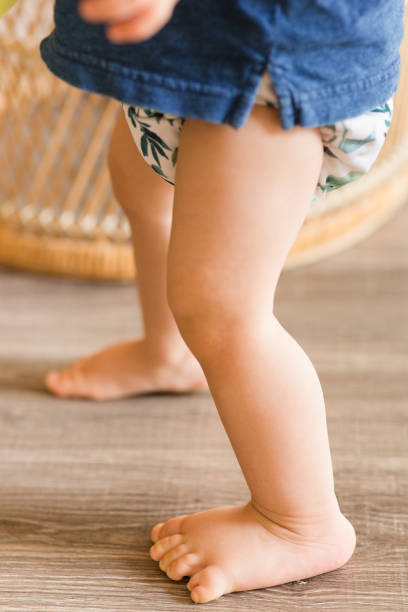 istock A 1-Year-Old Baby Boy Playing on the Floor & Learning to Walk While Wearing Just a Cloth Diaper With a Leaf Pattern & a Blue Shirt 1467743922