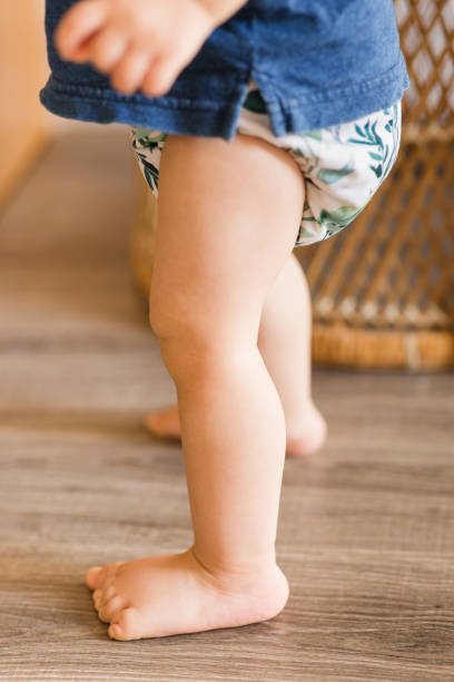 istock A 1-Year-Old Baby Boy Playing on the Floor & Learning to Walk While Wearing Just a Cloth Diaper With a Leaf Pattern & a Blue Shirt 1467743959