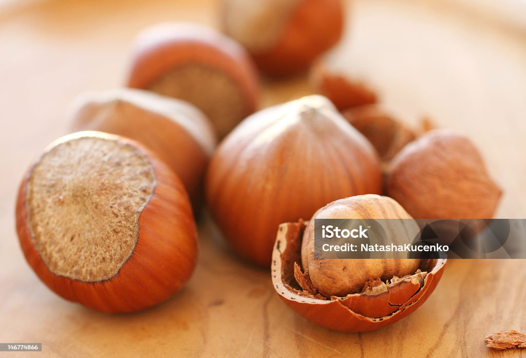 hazelnuts whole hazelnuts and chopped on a wooden board. Brown Stock Photo