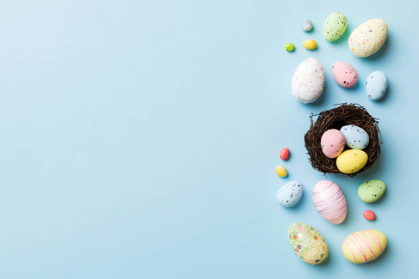 istock Colorful easter eggs in nest on table background with copy space top view 1467749099