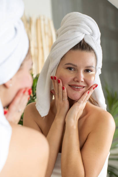 istock Attractive woman with patches under her eyes looks at her reflection in the mirror while smiling. 1467751854