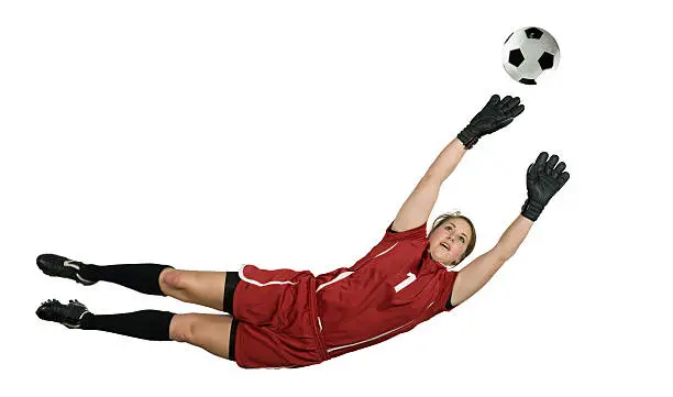 Soccer goalie leaps for the ball to block. Horizontal format.