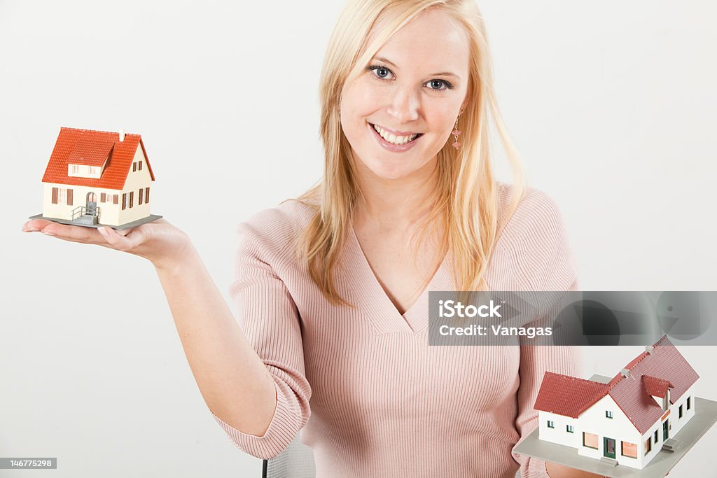 Jovem mulher equilibrando duas casas com as mãos - Foto de stock de Adulto royalty-free
