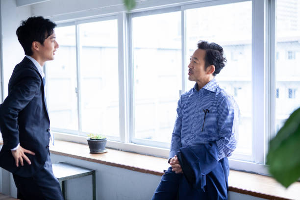 istock Two suited businessmen are having a meeting by an office window 1467754979