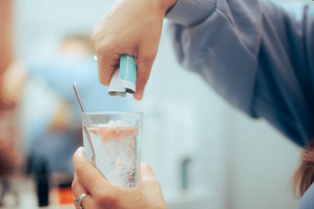 Hand Poring a Powder Medicine into a glass of water stock photo