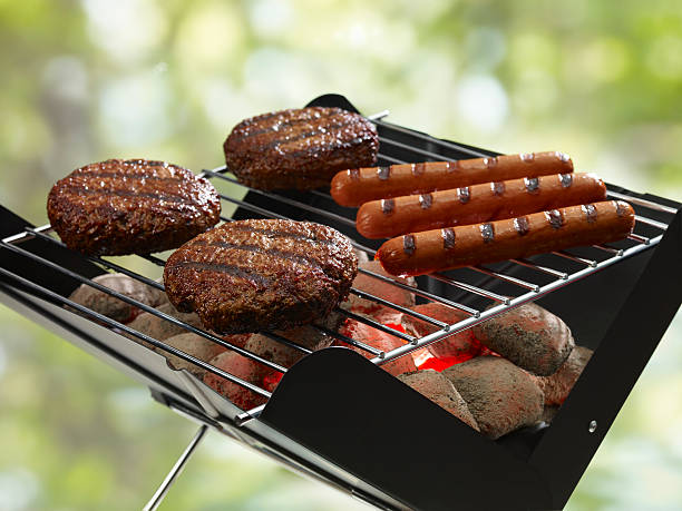 Hamburgers and hot dogs on a grill stock photo