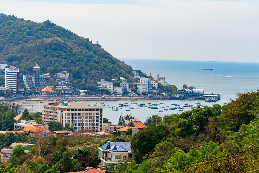 Vung Tau, VIETNAM - Feb 12 2023: Morning in Vung Tau seen from above, with the most beautiful sea waves, coastline, streets, buildings, coconut trees and Tao Phung mountain in Vietnam. Travel concept.