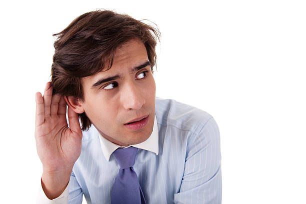 Young businessman, listening, viewing the  gesture of hand behind ear stock photo