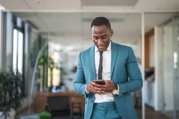 istock Black Mid Adult Man in a Suit Using a Mobile Phone 1467772419