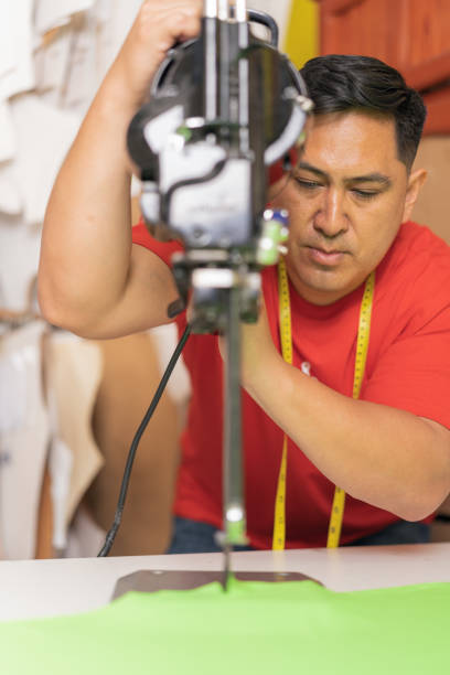 istock Man using an industrial machine to cut clothes with precision in a workshop 1467776693