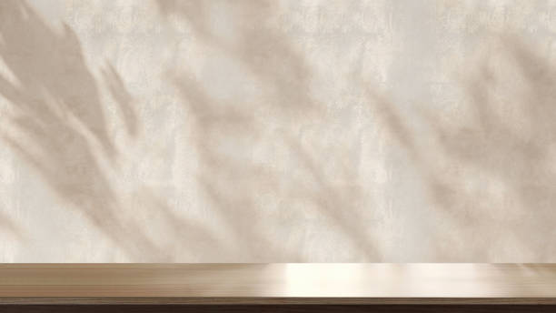 istock Wooden tabletop or countertop in beige stucco texture wall room with dappled sunlight, leaf shadow of tropical tree at home 1467776841