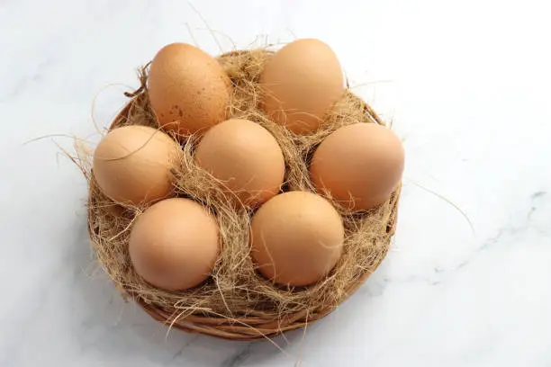 Photo of Brown Chicken eggs in a wooden basket. Hen eggs. organic brown eggs online shopping product photography. protein rich food. copy space. weight loss concept. Fitness journey. Anda bhurji ingredients.