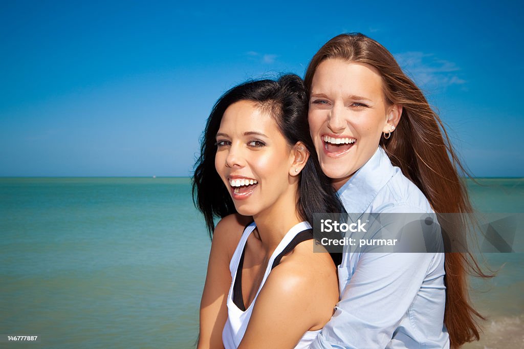 Smiling and laughing lesbian couple at the beach Lesbian couple at the beach laughing 20-29 Years Stock Photo