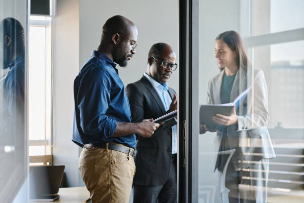 istock Young businessman preparing report while standing by his boss and colleague 1467780459