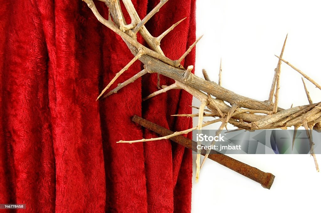 Crown of Thorns and Spike on Red Cloth Crown of Thorns with metal spike on red background. Christianity Stock Photo