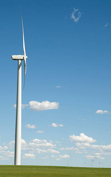 Side Windmill Side view of windmill with wind farm in distance. theishkid stock pictures, royalty-free photos & images