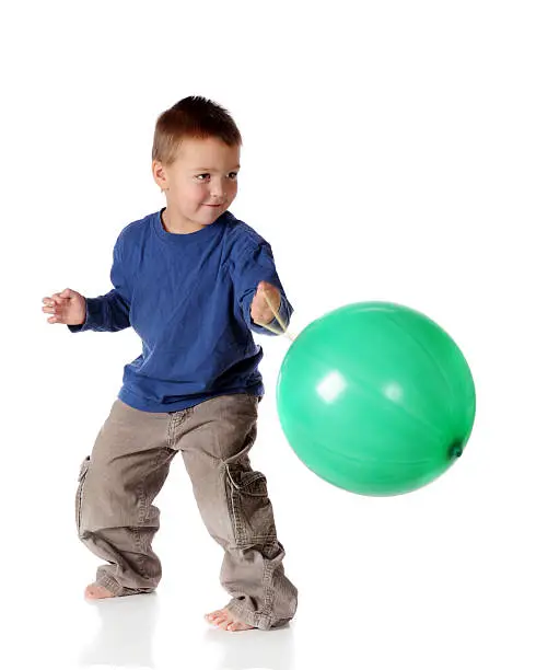 A preschooler eagerly punching an inflated punchball.  Isoalted on white.