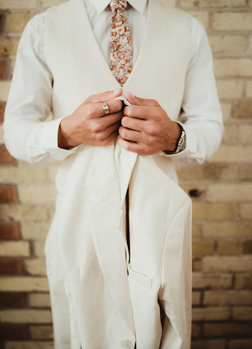 Groom dressing in all white clothing
