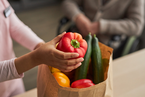 Volunteer delivering fresh vegetables to elderly man