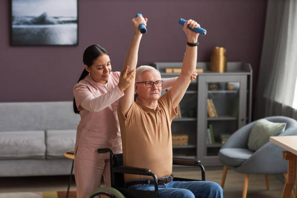 istock Volunteer helping senior man to exercise 1467798388