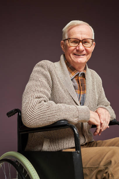 istock Smiling senior man sitting in wheelchair 1467798504