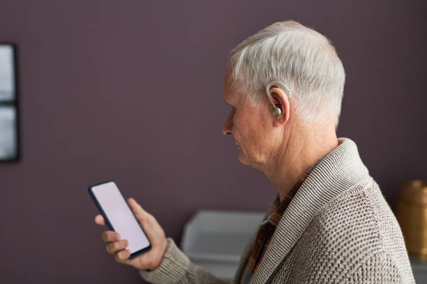 istock Elderly man with hearing aid listening audio on smartphone 1467798580