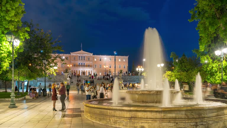 TL WS people in Syntagma Square ,People at Syntagma square, and Parliament Building night time Athens Greece