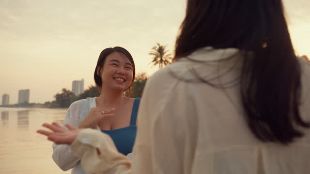 Closeup of young Asian female friends talking on tropical beach. Healthy active lifestyle and summer vacation.