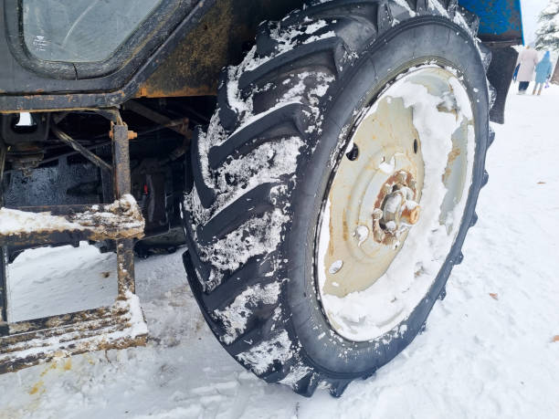 istock large wheels of a blue tractor in a snowy forest. 1467802797