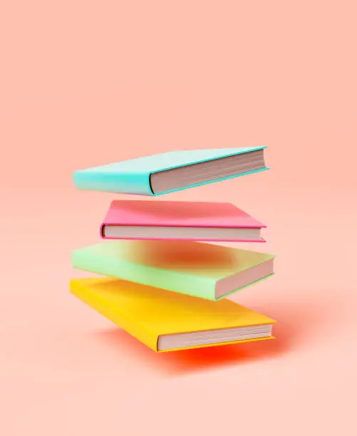 Photo of Stack of colorful books against pink background