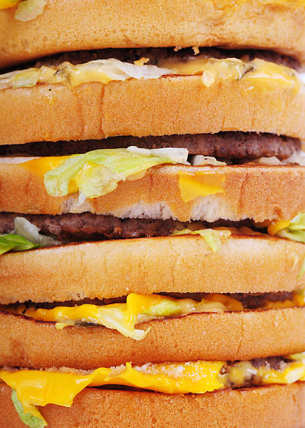 Five hamburgers in layers separated with buns and cheese stock photo