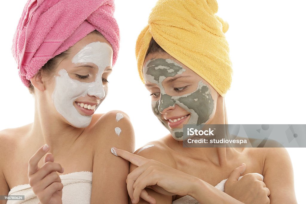 Young women with facial mask Two teenage girls applying clay facial mask 16-17 Years Stock Photo