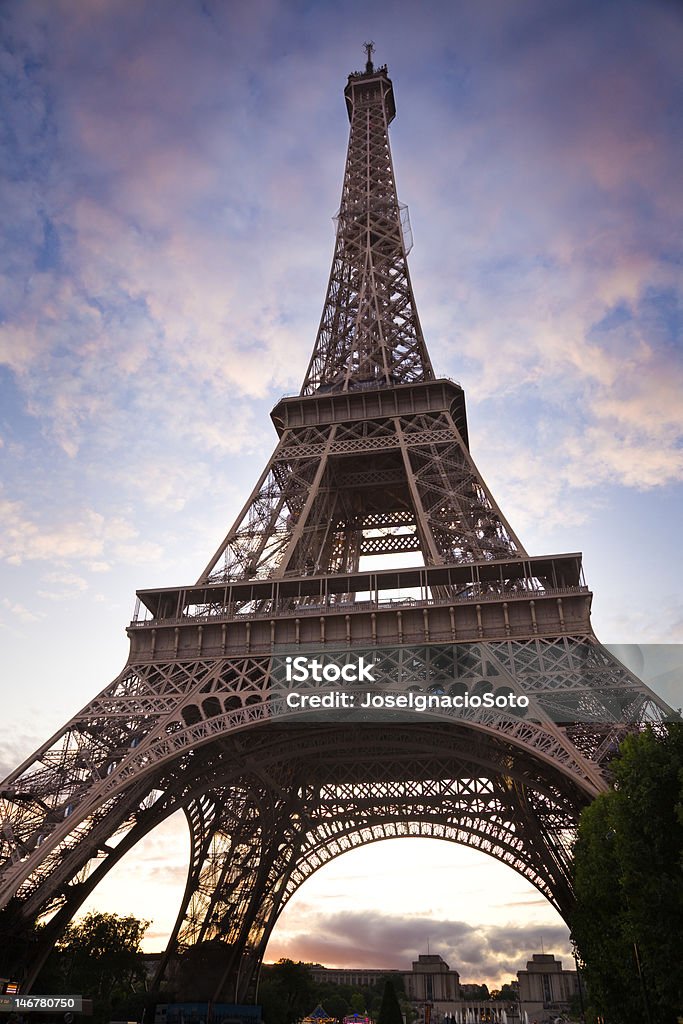 Torre Eiffel contro un cielo nuvoloso al tramonto - Foto stock royalty-free di Architettura