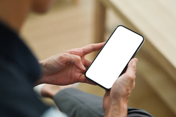 istock Close up view of man sitting couch and using smart phone. White empty screen for your advertise design. 1467807570