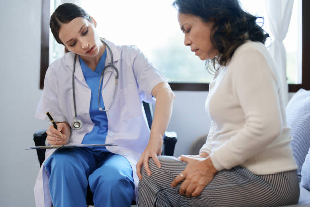 ritratto di una dottoressa che parla con una paziente con dolore al ginocchio. - patient doctor male talking foto e immagini stock